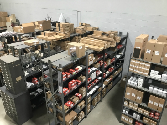 Multiple shelves full of boxes of Bobcat® parts inside a large warehouse.